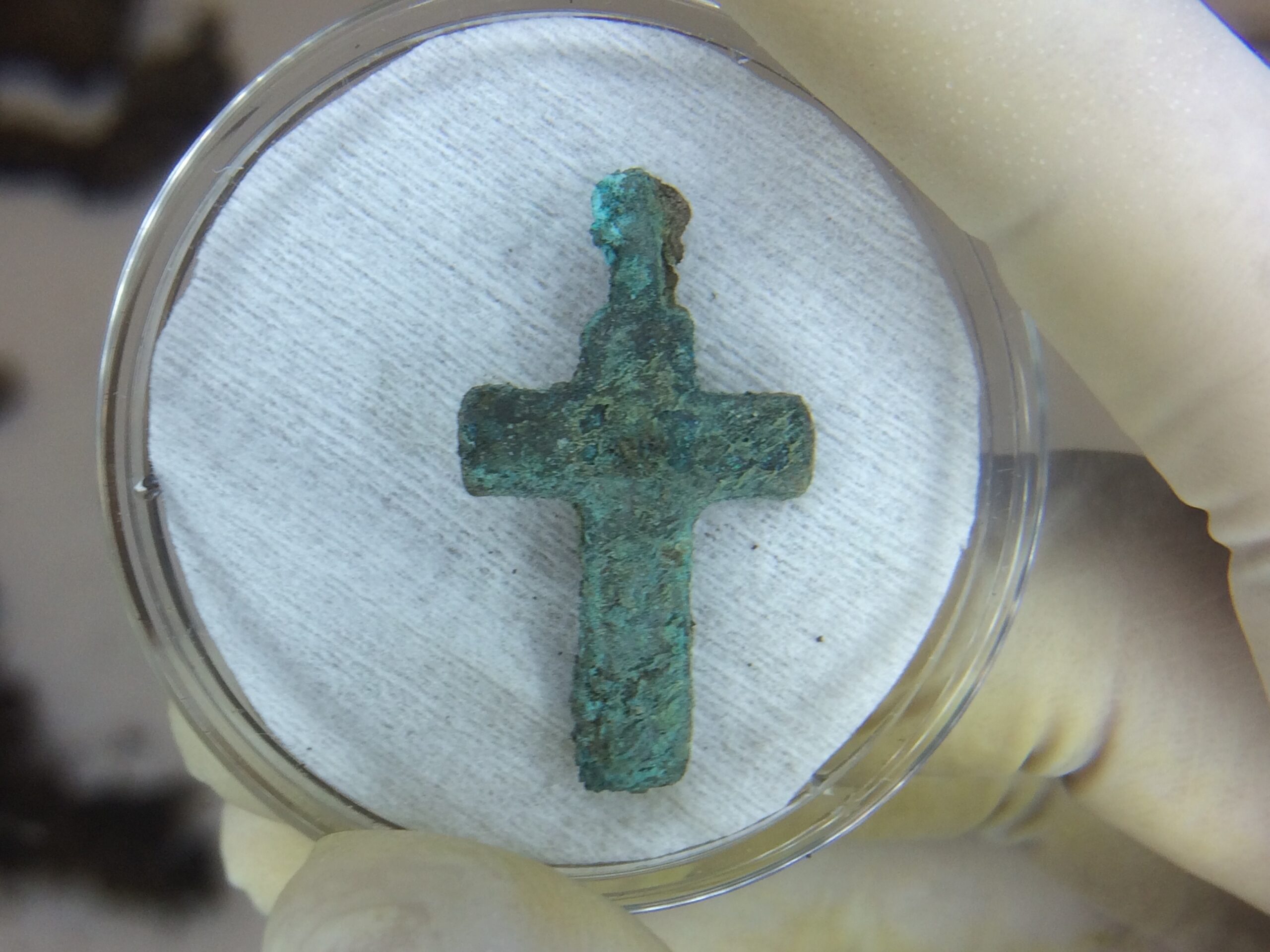 Metal cross from a burial at San Ignacio prior to conservation